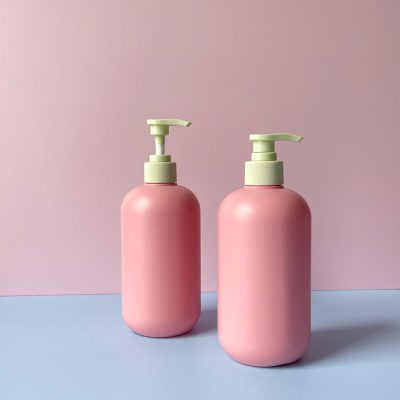 Chai nhựa HDPE hồng tròn với vòi nhấn sóng xanh nhạt sọc